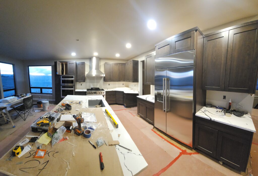 Modern kitchen remodel with dark wood cabinetry, stainless steel appliances, and under-cabinet lighting